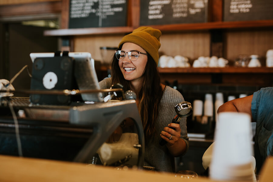 Smiling barista making espresso.