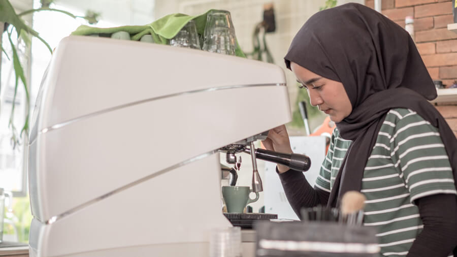 A woman making herself an espresso.