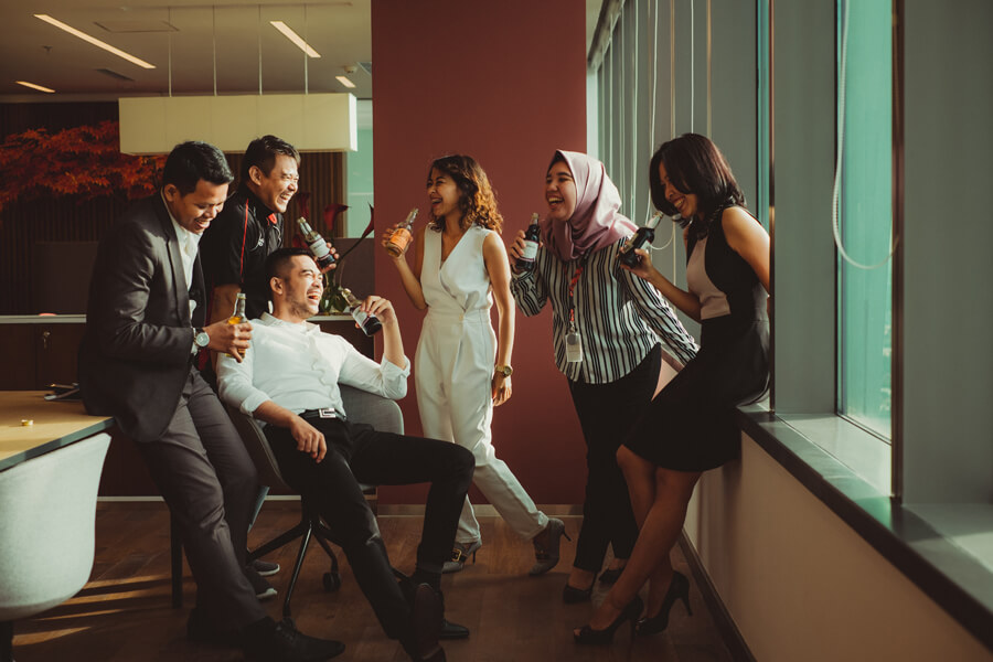 Business people laughing together while sharing a beverage.