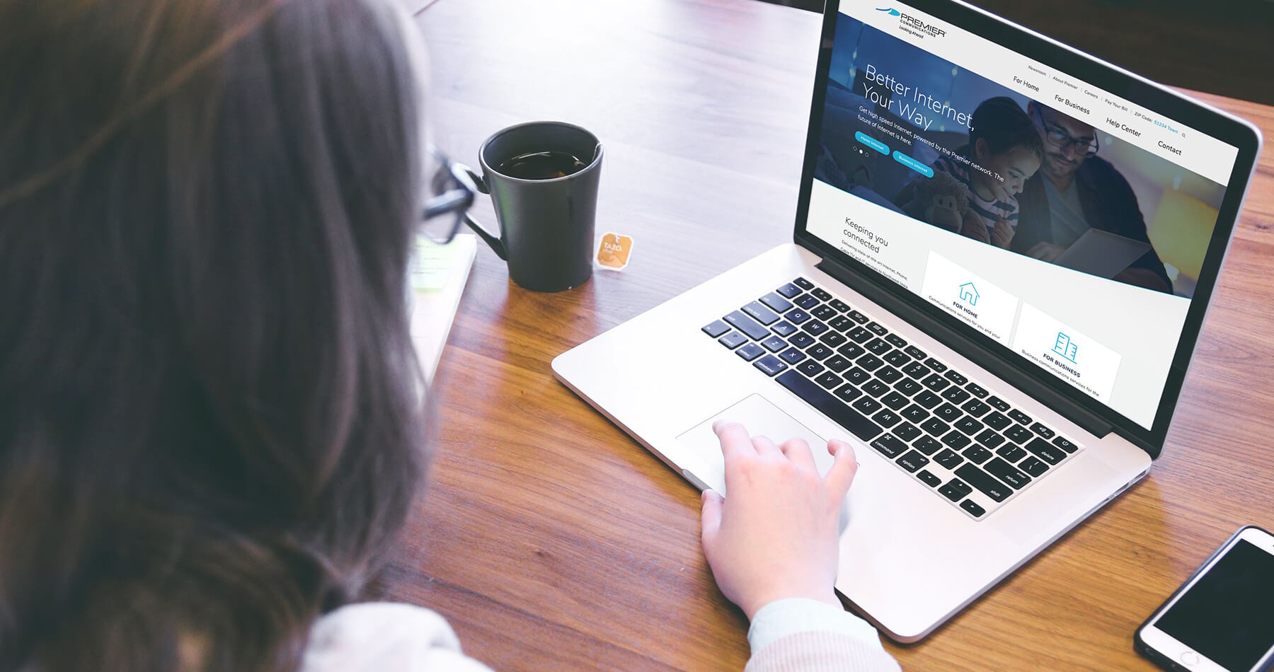 Woman Viewing Premier Communications' Website on a Laptop